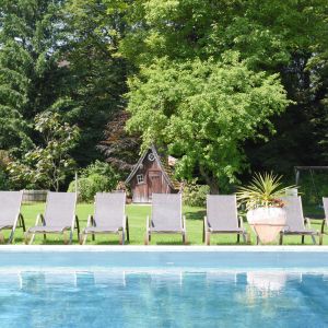 Schwimmbad mit Gartenhäuschen im Hintergrund