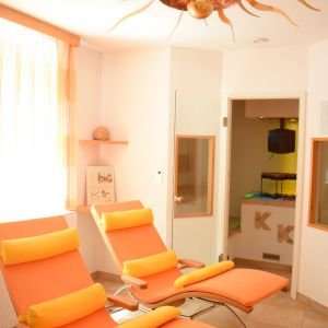 Ruhebereich mit Kräutersauna im Hintergrund